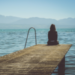 Woman sitting on the edge of a dock